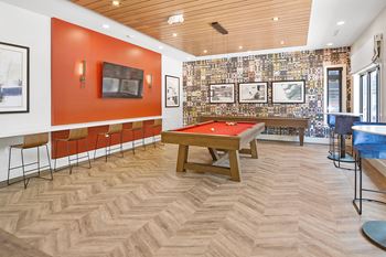a games room with a pool table and a television